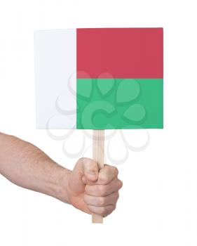 Hand holding small card, isolated on white - Flag of Madagascar