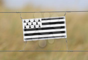 Border fence - Old plastic sign with a flag - Brittany