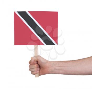 Hand holding small card, isolated on white - Flag of Trinidad and Tobago