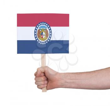 Hand holding small card, isolated on white - Flag of Missouri