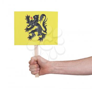 Hand holding small card, isolated on white - Flag of Flanders
