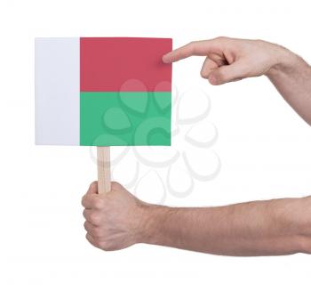 Hand holding small card, isolated on white - Flag of Madagascar