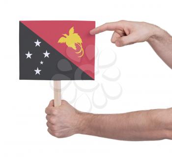 Hand holding small card, isolated on white - Flag of Papua New Guinea