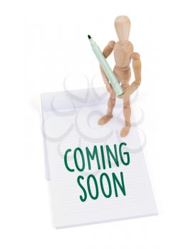 Wooden mannequin writing in a scrapbook - Coming soon