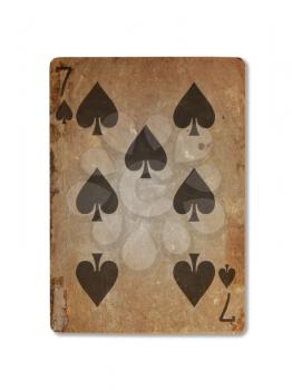Very old playing card isolated on a white background, seven of spades