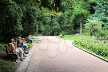 image of people having a rest in park with greater trees