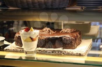 chocolate cake and glass with ice-cream in the shopwindow