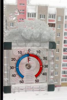 thermometer with layer of snow showing two degrees of frost