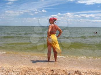 girl in bathing suit standing at the seacoast