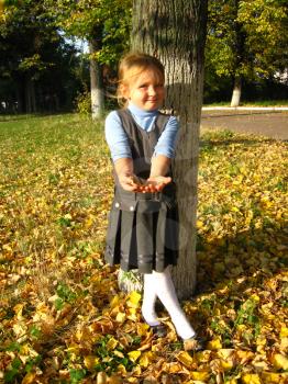 little girl with yellow leaf in the park in autumn