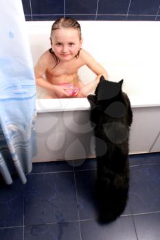 image of little girl taking a bath with curious black cat