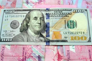 a hundred American dollars on the grivnas banknotes' background