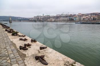 Shoes symbolizing the massacre of people shot at the river Danube in Budapest in a winter day