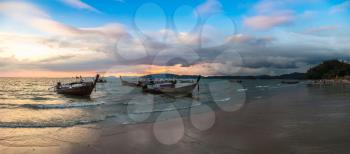 Panorama of Traditional long tail boat at sunset on Ao Nang beach, Thailand in a summer day