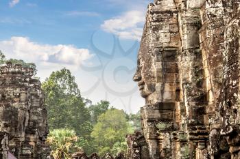 Stone faces of Bayon temple is Khmer ancient temple in complex Angkor Wat in Siem Reap, Cambodia in a summer day