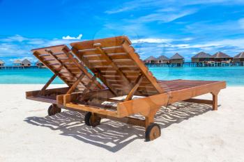MALDIVES - JUNE 24, 2018: Wooden sunbed on tropical beach in the Maldives at summer day