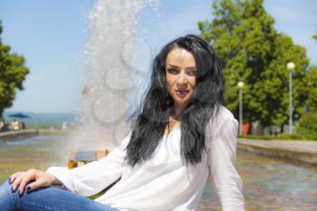 Photo of Caucasian brunette woman on fountain background