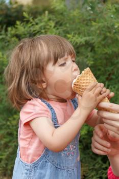 Vertical photo of cute girl are eating icecream in summer time