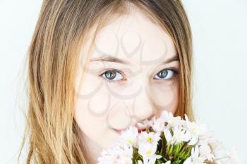Close portrait of girl eleven years old with big green eyes with white flowers
