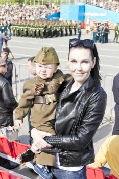 Samara, Russia - May 9, 2017: Mother with baby in soldier costume at the honor of annual Victory Day