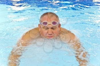 Big fat man in the swimming pool playing sports