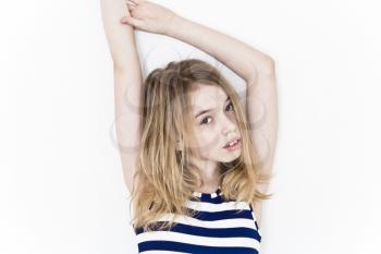 Girl eleven years old standing near white wall and upwards hands