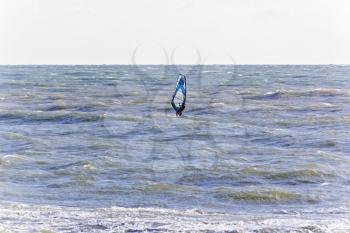 Horizontal photo of one surfer in open choppy sea