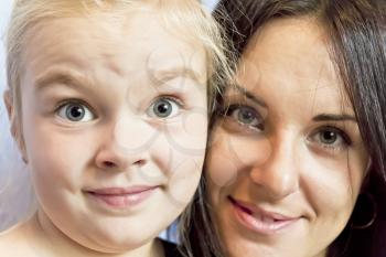 Portrait of cute blond daughter with brunette mother
