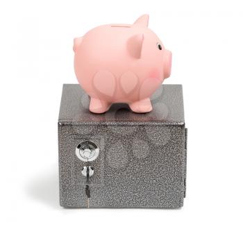 Piggy bank standing on a safe. Isolated on white