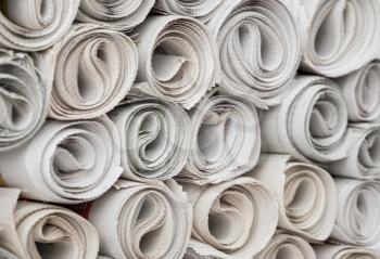 Stack of newspapers rolls, texture background.