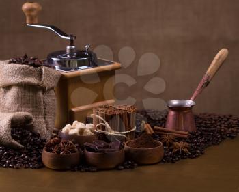 Still-life with coffee, cup with saucer, coffee mill, sac with beans and spices.