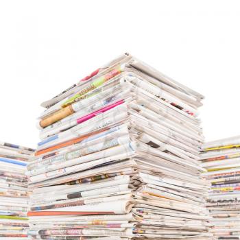 Three big stacks of newspapers isolated on white