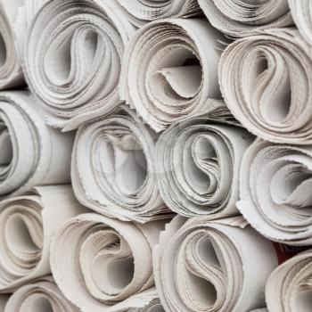 Stack of newspapers rolls, paper texture background.