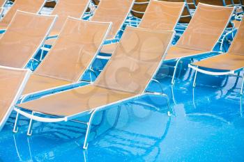 textile chairs on wet deck of cruise liner in rainy day
