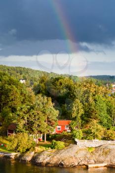 rainbow under small village on Baltic seashore