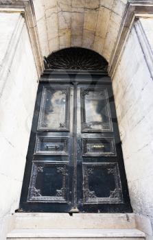 Old dark metal door with two pull in marble niche in Istanbul
