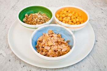 plate with three kind of cereals for breakfast on marble table
