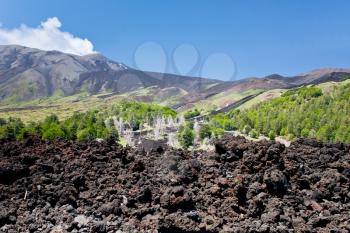 hardened lava close up with Etna on background