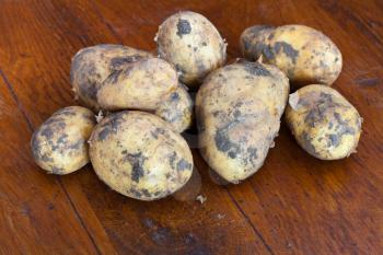 several yellow raw potatoes on wooden table