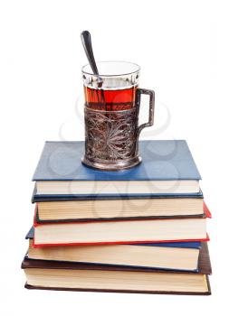 glass of tea on stack of books isolated on white background