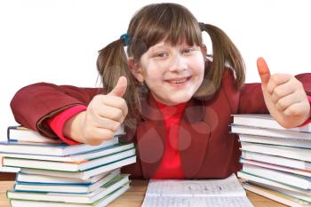 smiling schoolgirl did schoolwork and shows thumb-up
