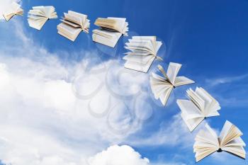 arch of flying books with blue sky and white cloud background