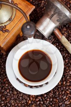 top view cup of coffee and roasted coffee beans with retro wooden manual grinder, coffee pot