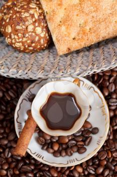 top view small cup of coffee and roasted coffee beans with cinnamon, biscuit