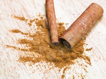 pinch of ground cinnamon and cinnamon bark close up