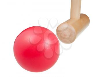 hitting red ball by wooden mallet in croquet game close up isolated on white background