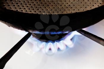 frying pan on burning gas in hearth ring of kitchen stove