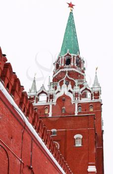 snow in Moscow - red Kremlin wall and Troitskaya Tower in winter snowing day
