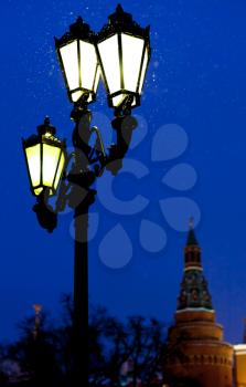 snow in Moscow - outdoor lantern and Kremlin tower in winter snowing evening