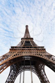 bottom view of Eiffel tower in Paris with white clouds on blue sky